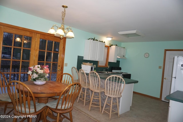 dining space with baseboards and a chandelier