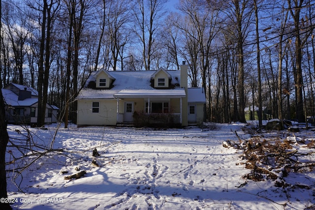 cape cod house with a porch and a chimney