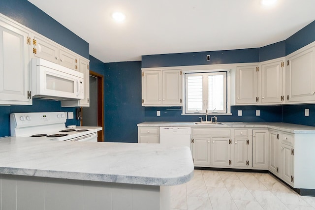 312 Columbia Ave, Palmerton, PA 18071 - kitchen featuring white appliances, light countertops, white cabinetry, light marble finish floors, and a peninsula