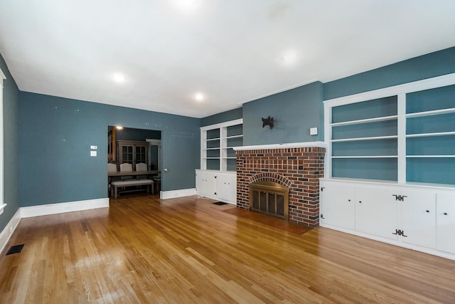 312 Columbia Ave, Palmerton, PA 18071 - unfurnished living room with wood finished floors, built in shelves, and a fireplace