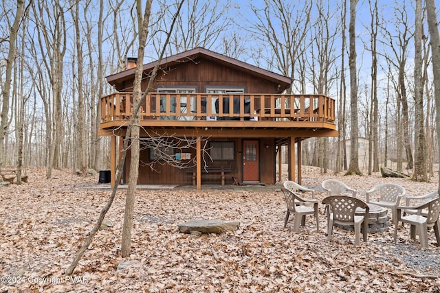 rear view of house featuring a chimney and a wooden deck