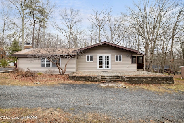 view of side of property with a patio area, french doors, and a chimney