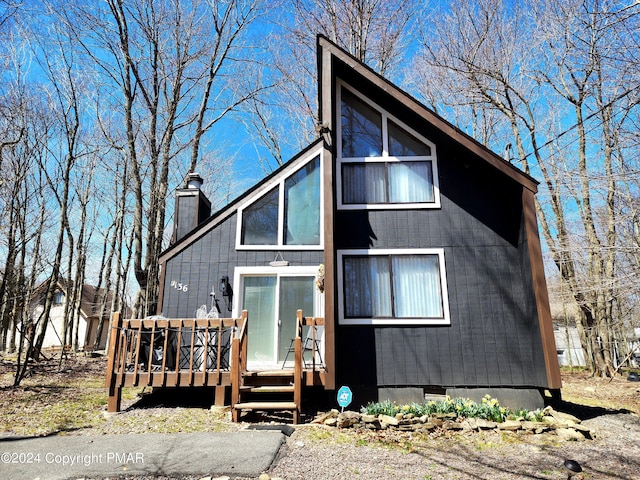 view of front of house featuring crawl space, a deck, and a chimney