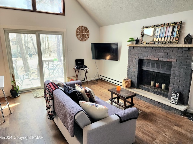 488 Country Place Dr, Tobyhanna, PA 18466 - living room featuring vaulted ceiling, wood finished floors, baseboard heating, and a textured ceiling