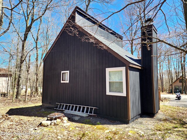 view of side of home with an outdoor fire pit