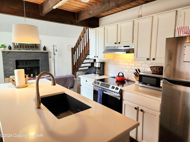 kitchen with sink, beamed ceiling, tasteful backsplash, pendant lighting, and stainless steel appliances