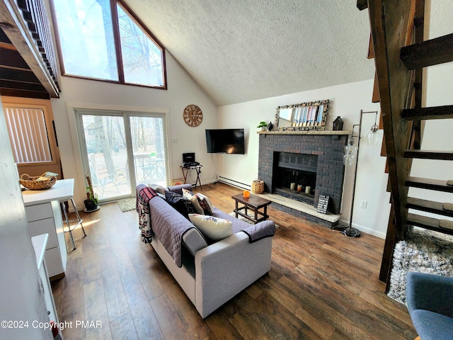 living room with dark wood-type flooring, a baseboard radiator, a brick fireplace, and a textured ceiling