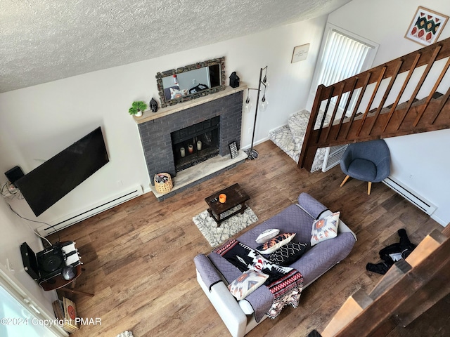 living room with hardwood / wood-style flooring, a textured ceiling, and a baseboard heating unit