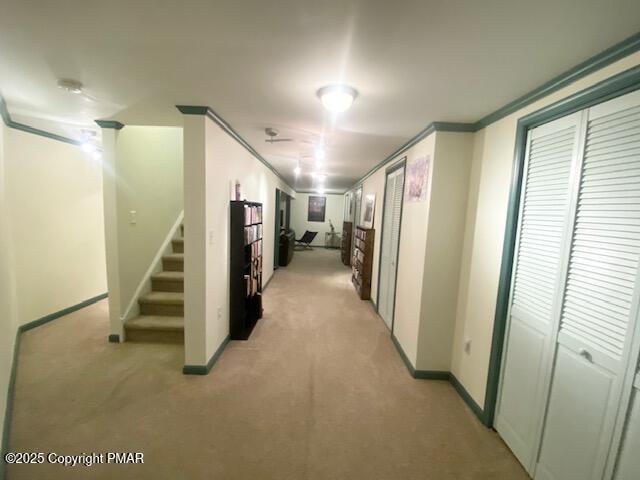 hallway with light carpet and crown molding