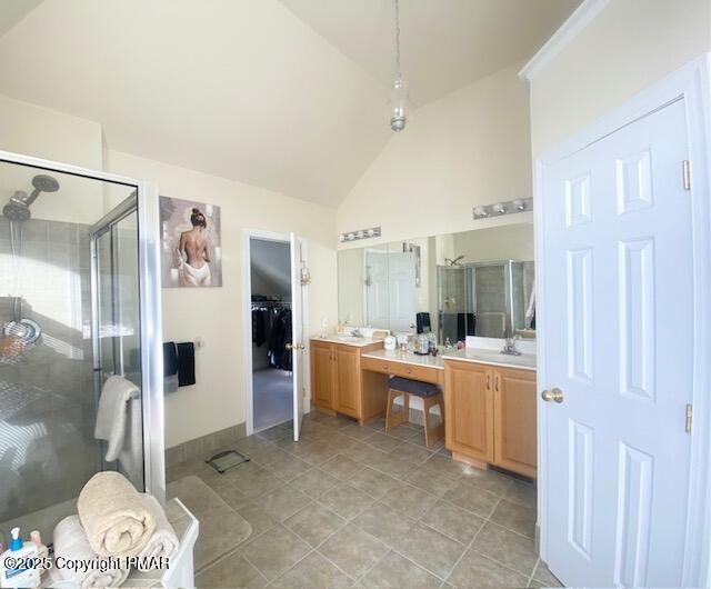 bathroom featuring tile patterned floors, a shower with door, vanity, and vaulted ceiling