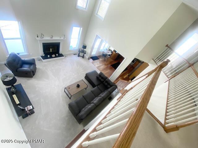 carpeted living room with a wealth of natural light and a high ceiling