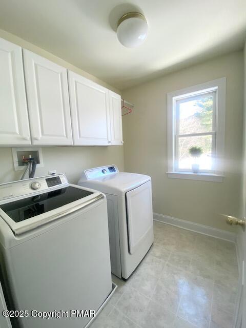 washroom with washing machine and clothes dryer and cabinets