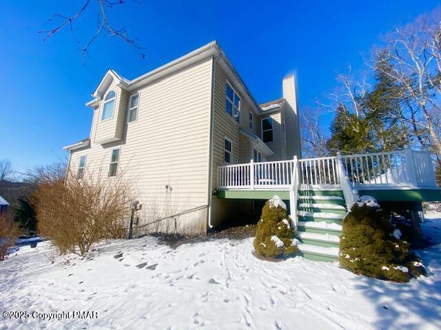 view of snow covered exterior featuring a deck