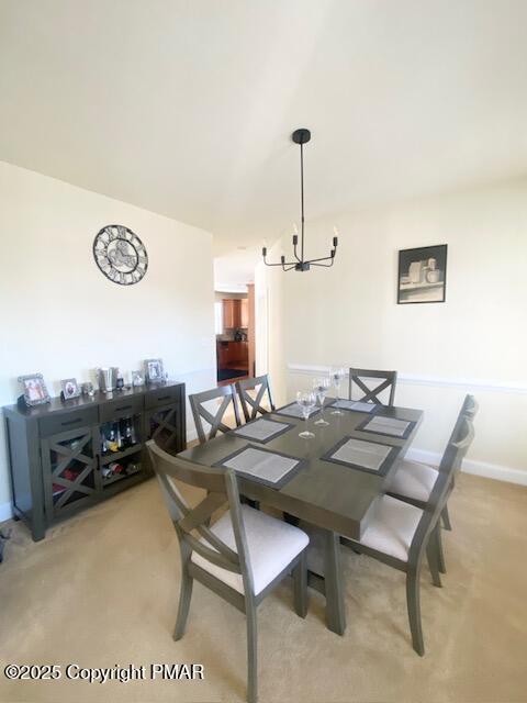 dining room featuring a notable chandelier and carpet floors