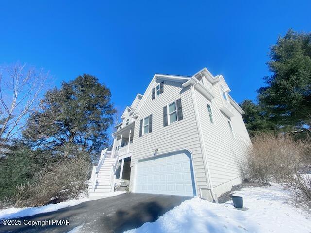 view of snowy exterior featuring a garage