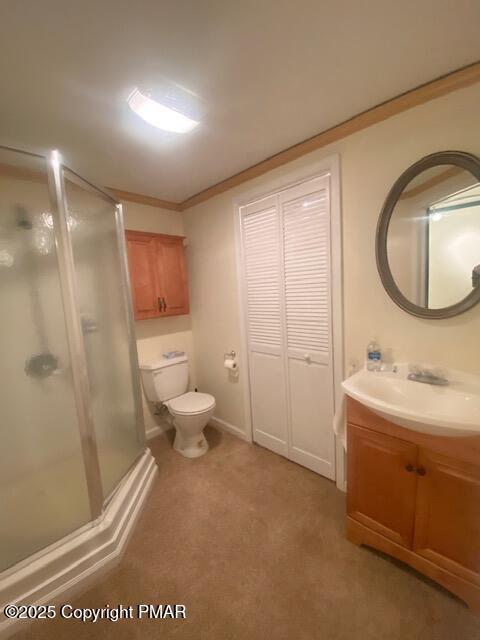 bathroom featuring an enclosed shower, vanity, crown molding, and toilet