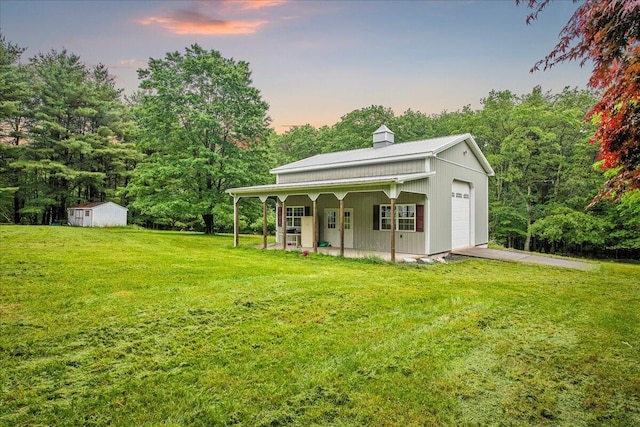 188 Cress Dr, Saylorsburg, PA 18353 - view of grassy yard featuring asphalt driveway, a porch, a garage, and a shed