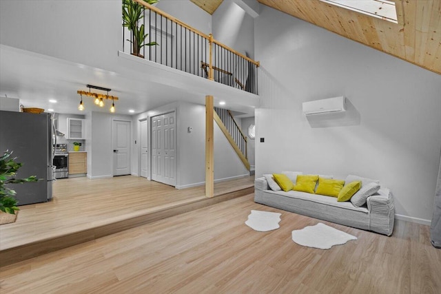 483 Alter Ave, Pocono Summit, PA 18346 - living room with stairway, baseboards, high vaulted ceiling, light wood-style flooring, and a skylight