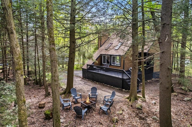 483 Alter Ave, Pocono Summit, PA 18346 - back of property featuring an outdoor fire pit, a wooden deck, a chimney, a shingled roof, and a view of trees