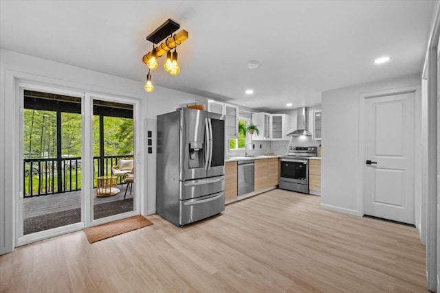 483 Alter Ave, Pocono Summit, PA 18346 - kitchen with appliances with stainless steel finishes, wall chimney range hood, light countertops, a sink, and light wood-style flooring