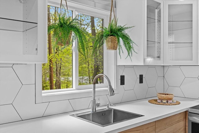 483 Alter Ave, Pocono Summit, PA 18346 - kitchen featuring a sink, backsplash, light countertops, glass insert cabinets, and plenty of natural light