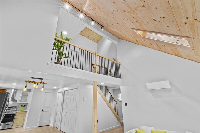 483 Alter Ave, Pocono Summit, PA 18346 - stairway featuring wood finished floors, high vaulted ceiling, wood ceiling, a wall unit AC, and baseboards