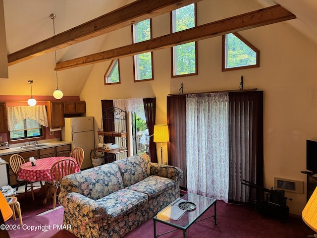 living room featuring a wealth of natural light, beam ceiling, and visible vents