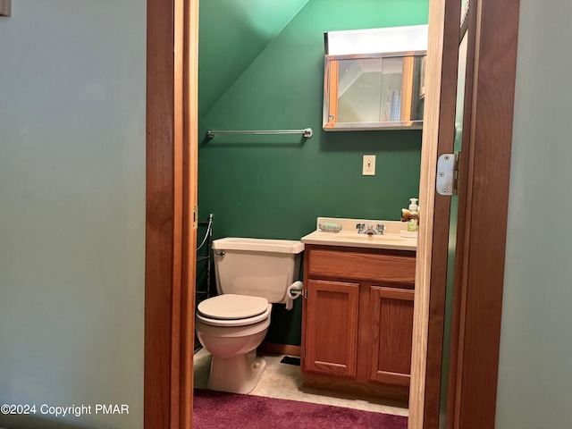 half bathroom with toilet, vanity, and lofted ceiling