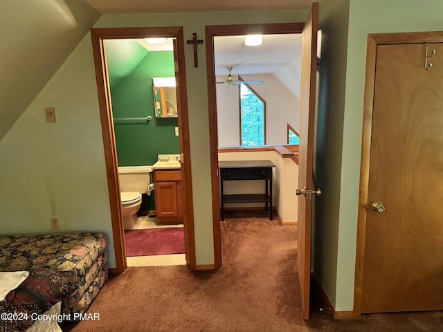 hall with carpet flooring, vaulted ceiling, and baseboards