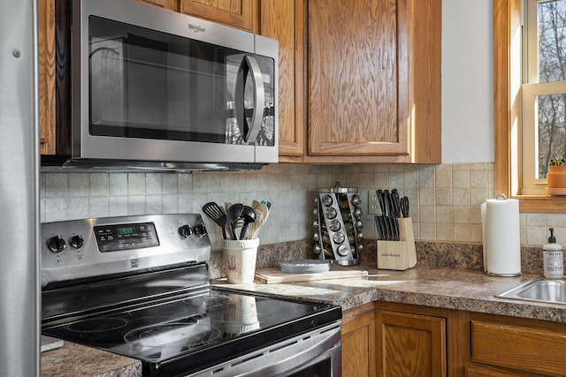 225 N Arrow Dr, Pocono Lake, PA 18347 - kitchen with stainless steel appliances, brown cabinets, and tasteful backsplash