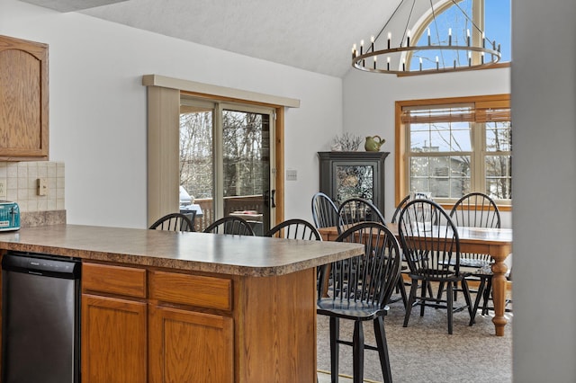 225 N Arrow Dr, Pocono Lake, PA 18347 - kitchen featuring stainless steel dishwasher, a peninsula, lofted ceiling, a kitchen bar, and backsplash