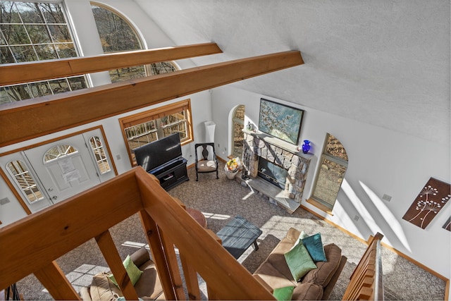 225 N Arrow Dr, Pocono Lake, PA 18347 - carpeted living room featuring vaulted ceiling, a stone fireplace, and a textured ceiling