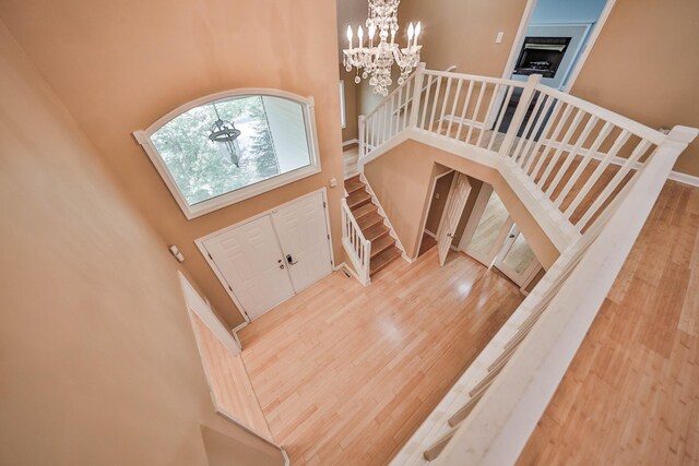 205 Osprey Way E, Stroudsburg, PA 18302 - entryway with a high ceiling, wood finished floors, a chandelier, stairs, and a fireplace