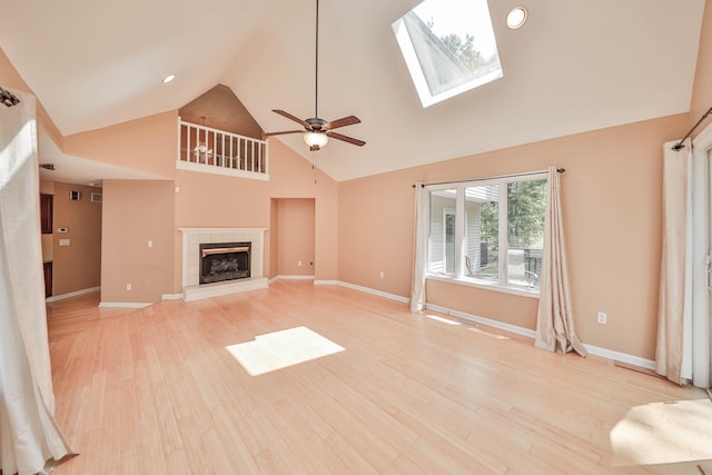 205 Osprey Way E, Stroudsburg, PA 18302 - unfurnished living room featuring high vaulted ceiling, ceiling fan, light wood-style floors, a tiled fireplace, and baseboards