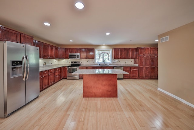 205 Osprey Way E, Stroudsburg, PA 18302 - kitchen featuring appliances with stainless steel finishes, a sink, light wood finished floors, a center island, and baseboards