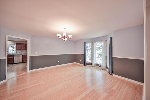 205 Osprey Way E, Stroudsburg, PA 18302 - empty room featuring light wood-style flooring, a chandelier, and baseboards