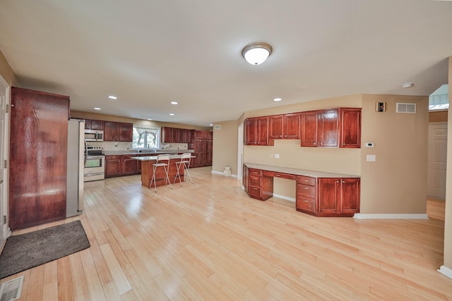 205 Osprey Way E, Stroudsburg, PA 18302 - kitchen with stainless steel appliances, a breakfast bar, light wood-style floors, baseboards, and recessed lighting