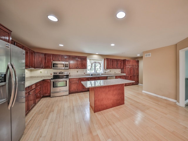 205 Osprey Way E, Stroudsburg, PA 18302 - kitchen featuring appliances with stainless steel finishes, a sink, a center island, light wood-style flooring, and recessed lighting
