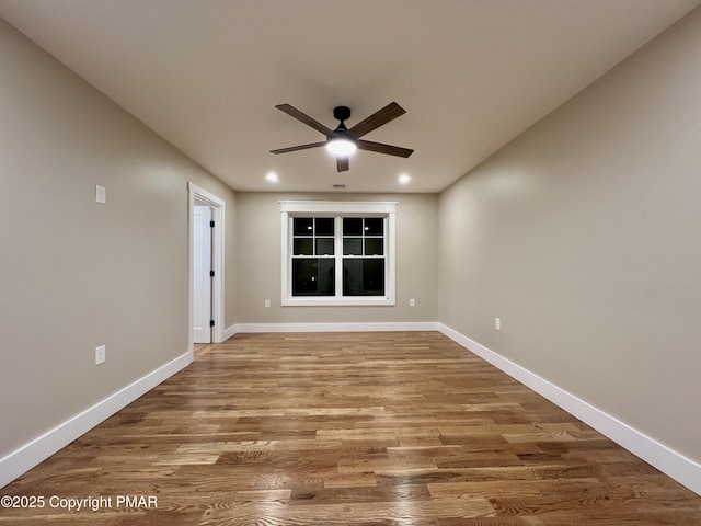 empty room with ceiling fan, recessed lighting, wood finished floors, and baseboards