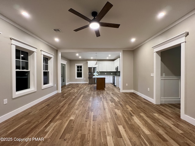 unfurnished living room featuring baseboards, ornamental molding, and dark wood-style flooring