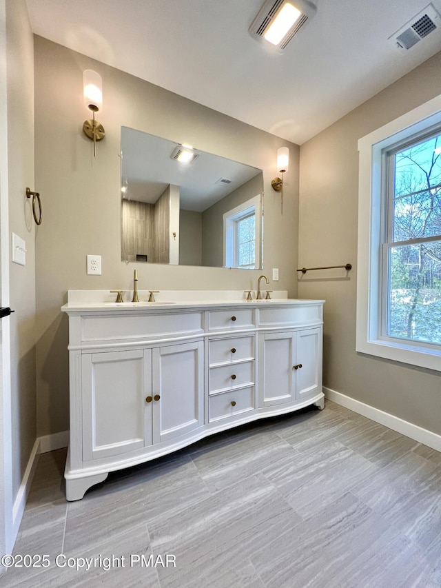 full bathroom featuring double vanity, visible vents, and a healthy amount of sunlight