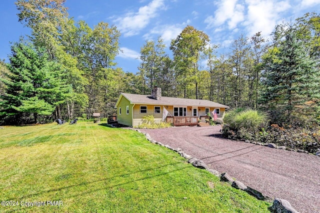 single story home featuring a front yard, gravel driveway, covered porch, and a chimney