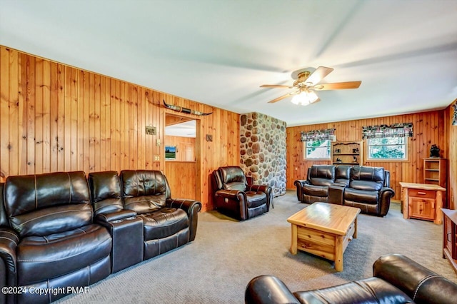 carpeted living area with a ceiling fan and wooden walls