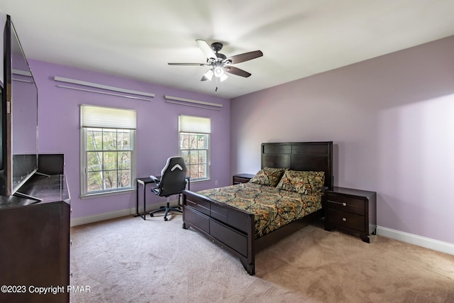 bedroom featuring a ceiling fan, light carpet, and baseboards