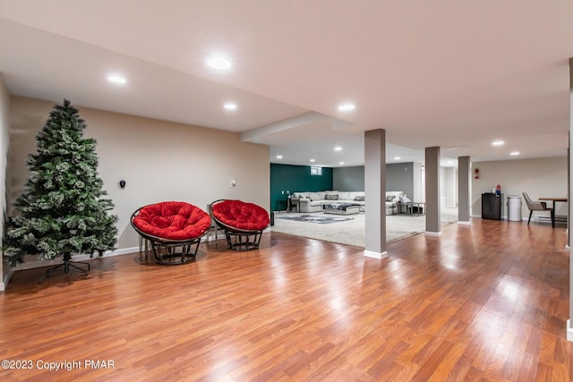 sitting room with baseboards, wood finished floors, and recessed lighting