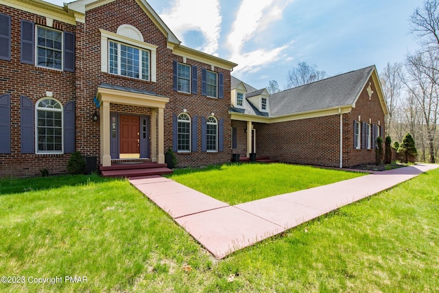 view of front of property featuring a front yard and brick siding