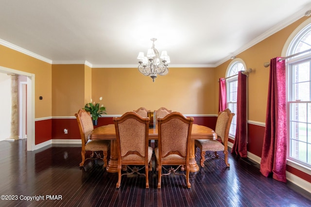 dining space featuring a healthy amount of sunlight, baseboards, a chandelier, and wood finished floors