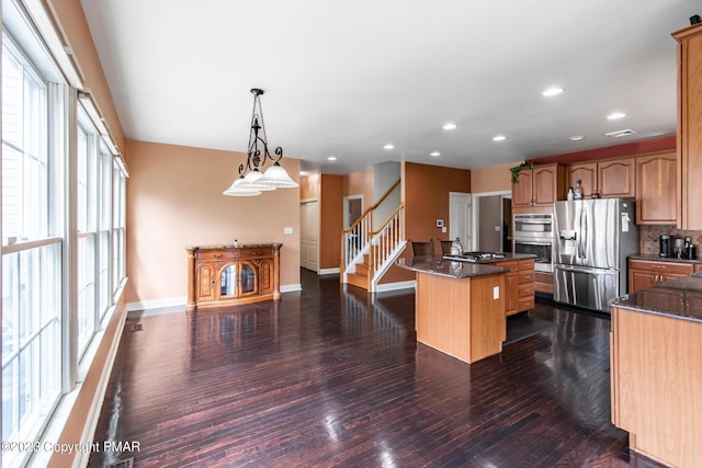 kitchen featuring recessed lighting, stainless steel appliances, dark wood-type flooring, baseboards, and a center island