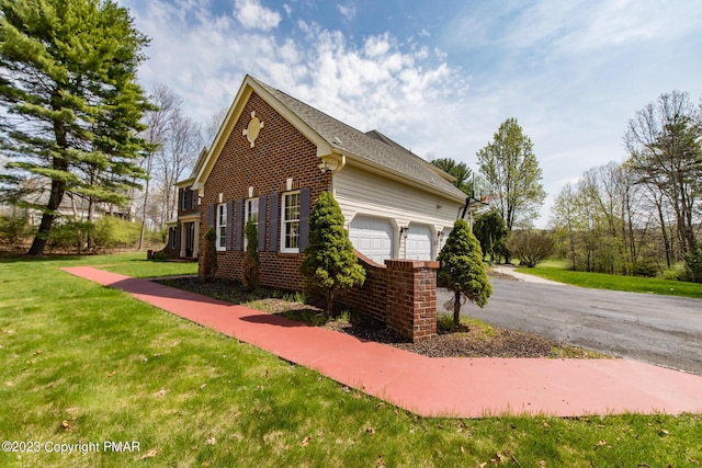 view of home's exterior featuring brick siding, a yard, and an attached garage