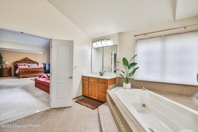 ensuite bathroom with ensuite bathroom, a whirlpool tub, tile patterned floors, vaulted ceiling, and vanity